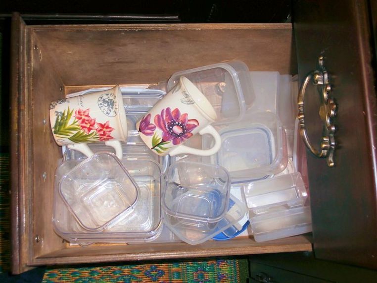Mugs in a drawer mong the leftover containers