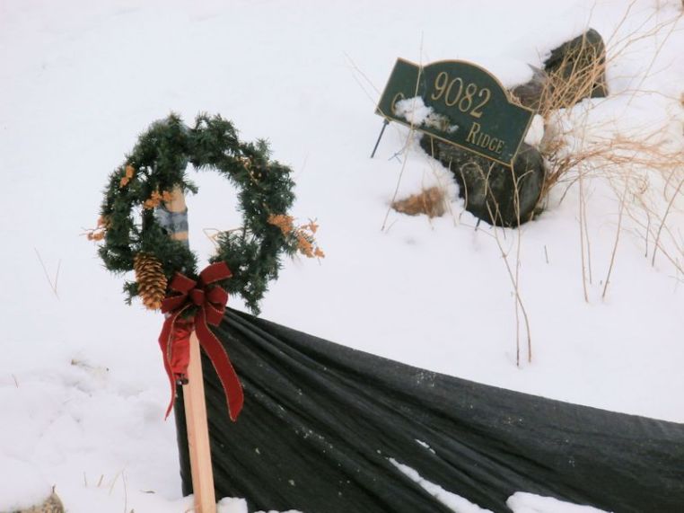 Christmas wreath duct taped it toa post on the silt fence.