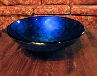 a blue vessle sink wihtout the water faucet or any other plumbing sitting in the middle of a coffee table