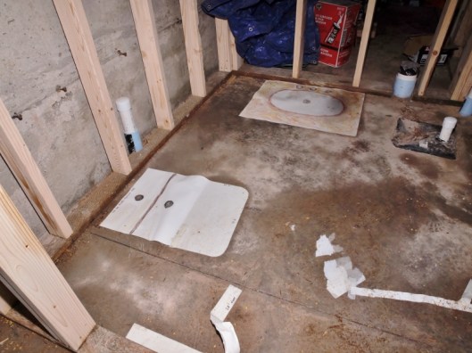 framed basement bathroom with templates of a toilet and a sink.
