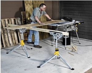 man cutting plywood on a table saw using two Rockwell Jawstands with a 2 x 4 between them to balance the other end of the plywood.