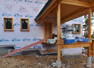 front entry of a house under construction showing ladder leaning against the above ground porch