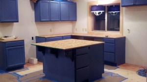 kitchen under construction with cabinets in place, no appliances or sink