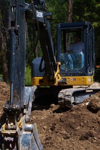 small excavator with bucket in front digging dirt