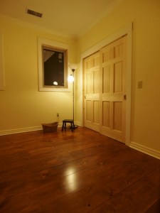 room with basket, stool and lamp showing newly finished floor which is a deep red brown with a satin finish